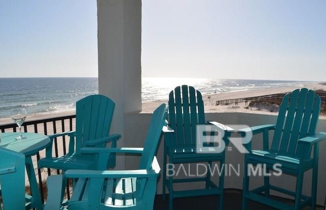 balcony featuring a water view and a beach view