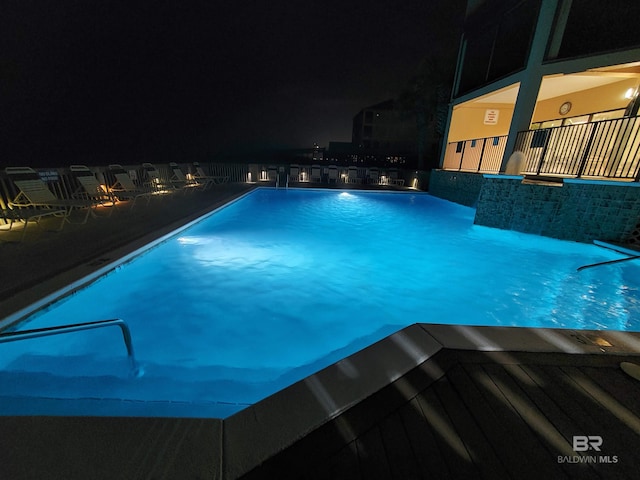 view of pool at twilight