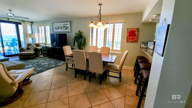 dining room with plenty of natural light, light tile patterned floors, and ceiling fan with notable chandelier