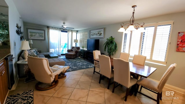 dining space featuring ceiling fan with notable chandelier, a healthy amount of sunlight, and light tile patterned floors