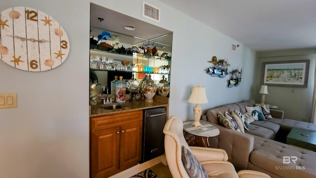 bar with dark stone countertops and sink