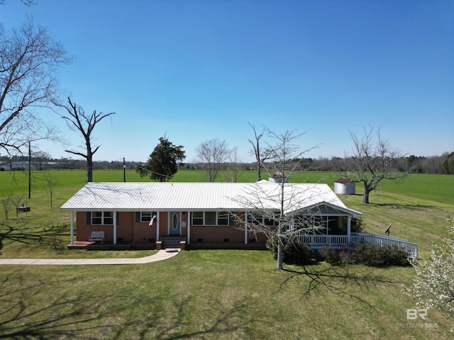 view of front of home featuring crawl space, covered porch, a front lawn, and metal roof