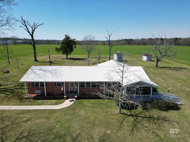 view of front of home with brick siding, crawl space, a rural view, and a front lawn