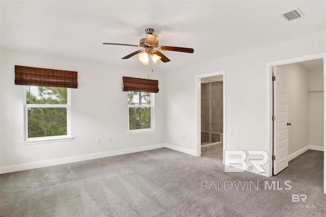 unfurnished bedroom with visible vents, baseboards, connected bathroom, a spacious closet, and carpet floors