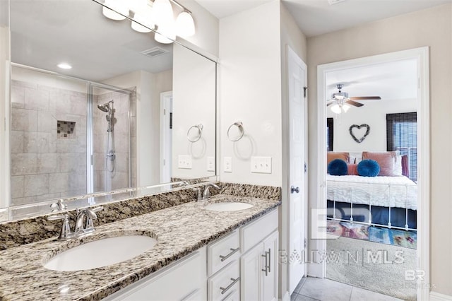 ensuite bathroom featuring ensuite bathroom, a stall shower, a sink, and tile patterned floors