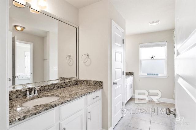 bathroom with vanity, baseboards, and tile patterned floors