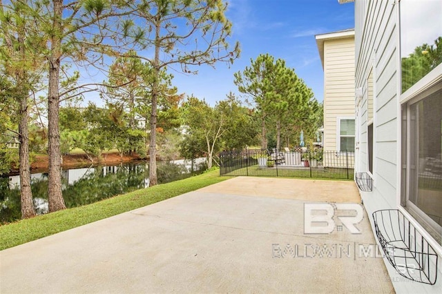 view of patio / terrace with a water view and fence