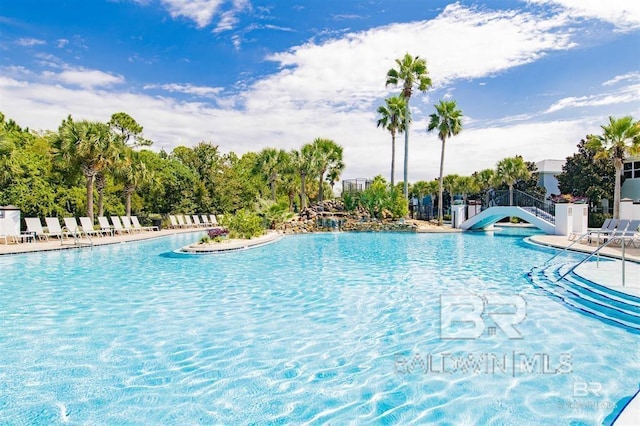 pool with a patio area and fence