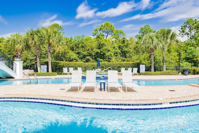 pool featuring fence and a patio