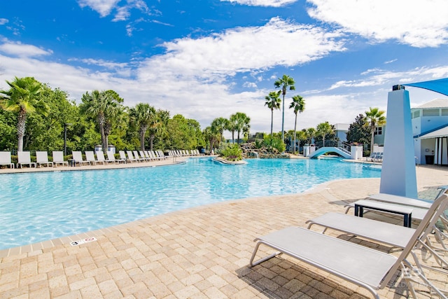 pool featuring a water slide and a patio area