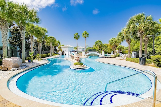 community pool featuring fence and a patio