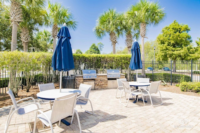 view of patio / terrace with outdoor dining space, grilling area, exterior kitchen, and fence