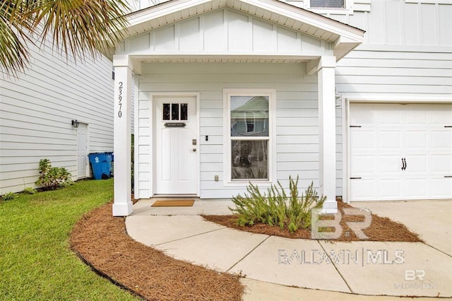 doorway to property with board and batten siding and a lawn