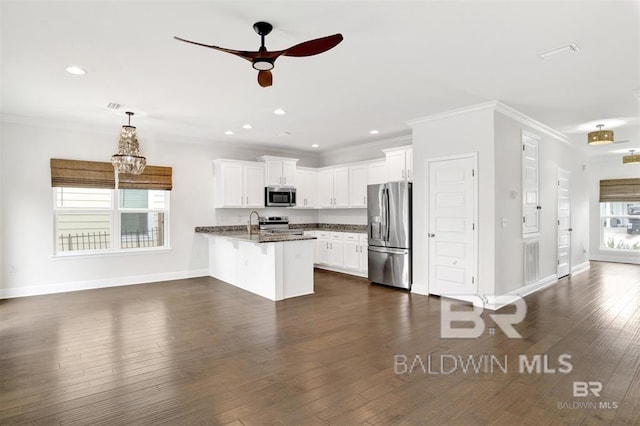 kitchen featuring a peninsula, appliances with stainless steel finishes, a breakfast bar area, and ornamental molding