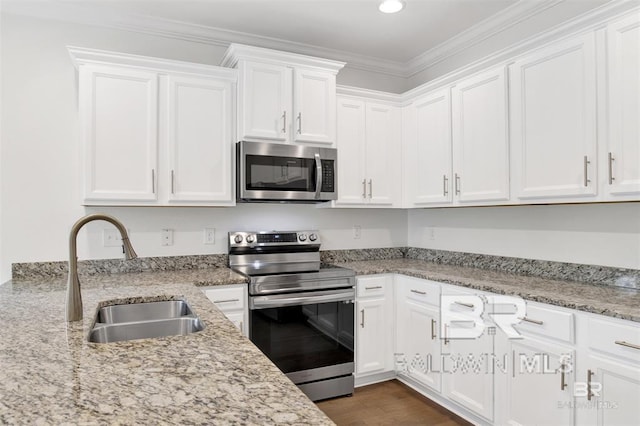 kitchen featuring stainless steel appliances, a sink, and white cabinets