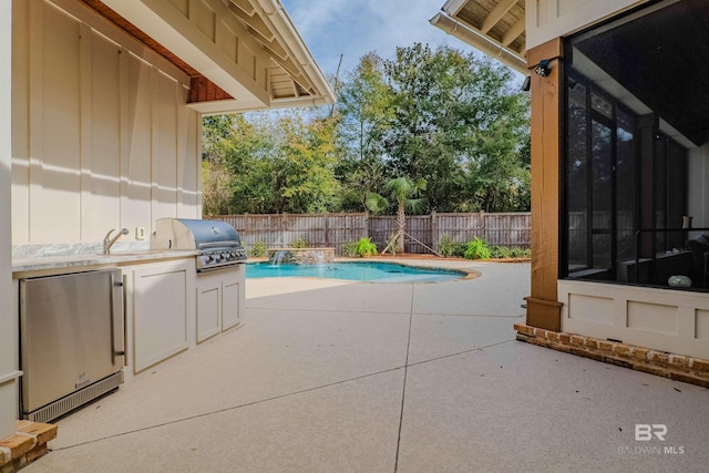 view of swimming pool with a patio, a sunroom, area for grilling, grilling area, and pool water feature