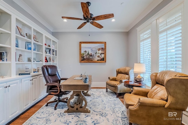 office space with crown molding, light wood-type flooring, and ceiling fan