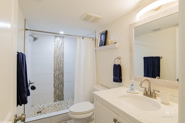 full bath featuring vanity, toilet, visible vents, and a stall shower