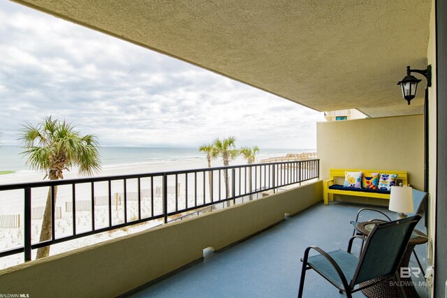 balcony featuring a water view and a view of the beach