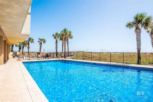 pool with a patio and fence