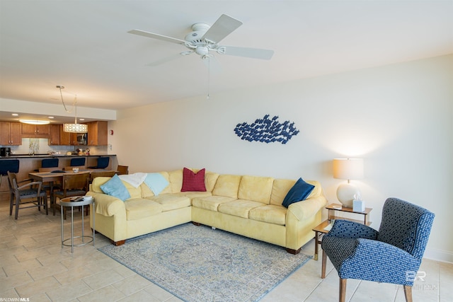 living area featuring light tile patterned floors and ceiling fan