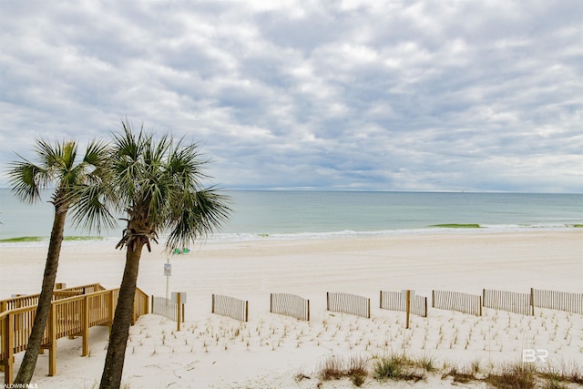 view of water feature with a view of the beach and fence