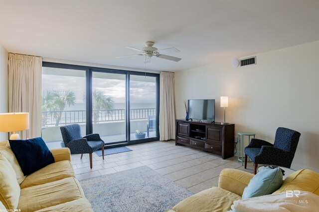 living room featuring a healthy amount of sunlight, floor to ceiling windows, light tile patterned floors, and ceiling fan