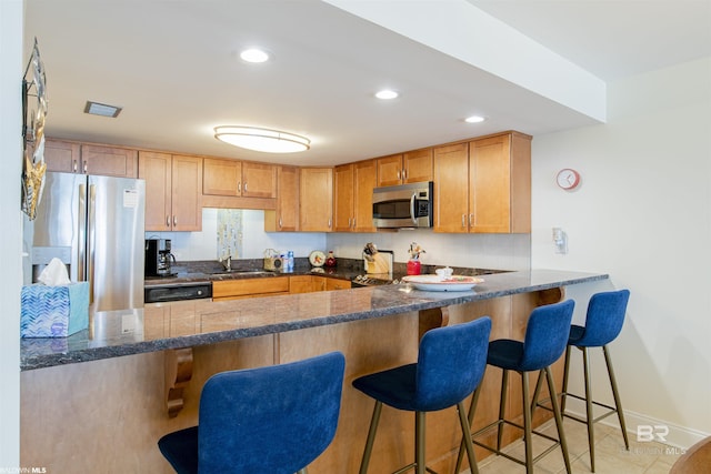 kitchen featuring recessed lighting, appliances with stainless steel finishes, a peninsula, and a sink