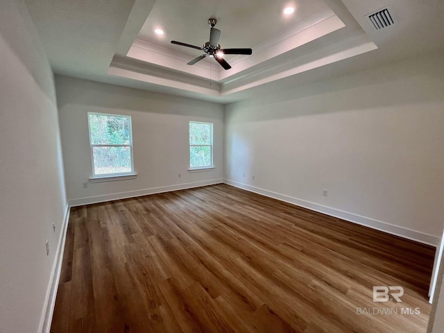 spare room with a raised ceiling, ceiling fan, and hardwood / wood-style flooring