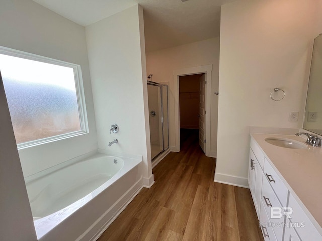 bathroom featuring vanity, wood-type flooring, and shower with separate bathtub