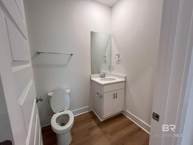 bathroom with hardwood / wood-style floors, vanity, and toilet