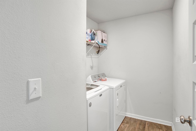 laundry room with washing machine and dryer and wood-type flooring