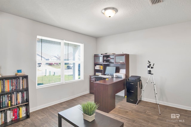 office with dark wood-type flooring and a textured ceiling