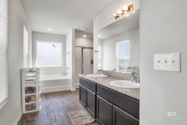 bathroom featuring a textured ceiling, vanity, independent shower and bath, and wood-type flooring