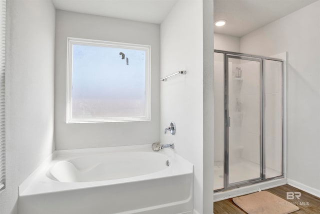 bathroom featuring hardwood / wood-style flooring, shower with separate bathtub, and a healthy amount of sunlight