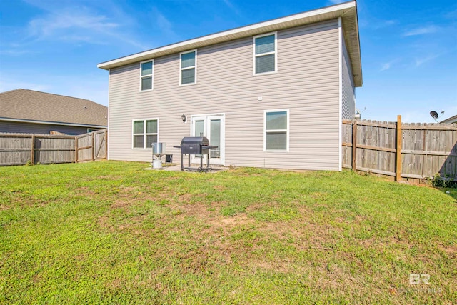 back of house featuring a patio area and a lawn