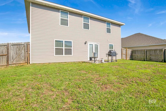 rear view of house featuring a lawn and a patio area