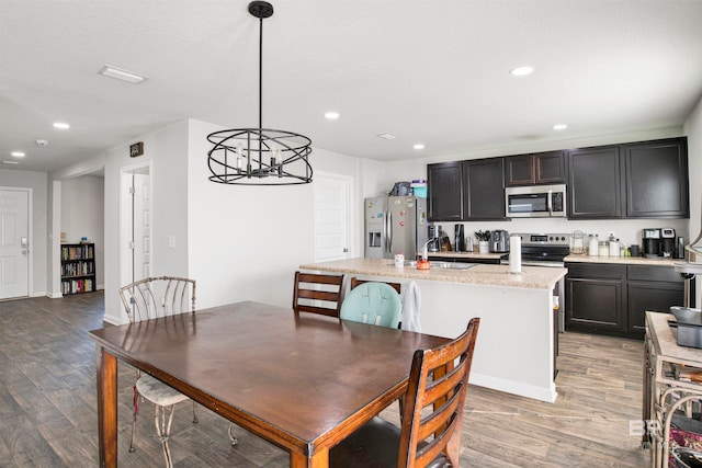 dining room with a notable chandelier, sink, and light wood-type flooring