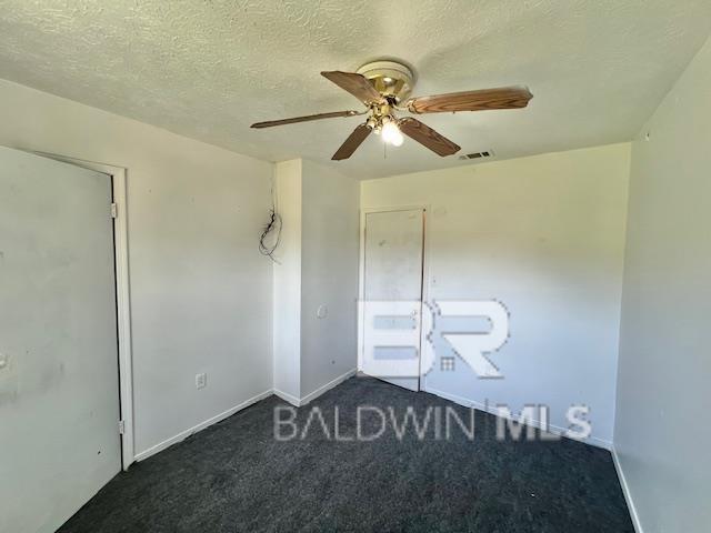208 Lee St, Atmore, AL 36502 - empty room with a textured ceiling, ceiling fan, baseboards, carpet flooring, and visible vents