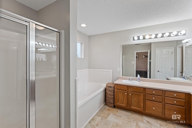 full bath featuring a textured ceiling, a stall shower, vanity, and a bath