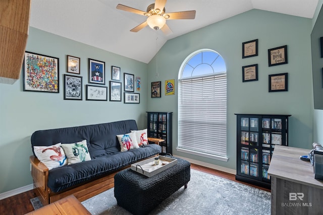 living area with lofted ceiling, ceiling fan, wood finished floors, and baseboards