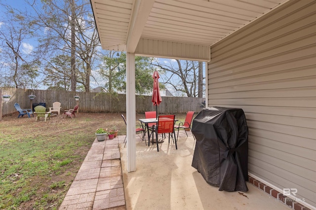 view of patio / terrace with outdoor dining space, a fenced backyard, a fire pit, and grilling area