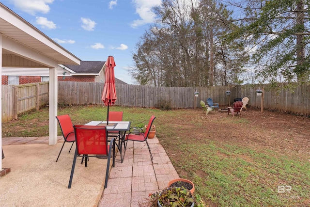 view of yard with a patio area, a fenced backyard, and outdoor dining area