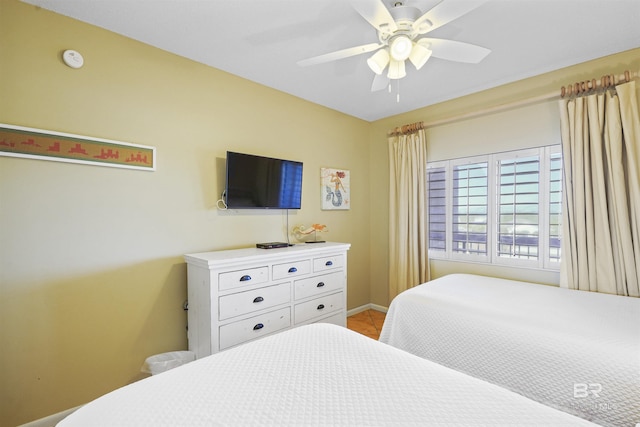 bedroom with a ceiling fan and baseboards