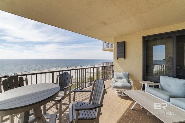 balcony with a water view and a view of the beach