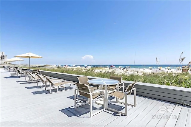 wooden terrace with a water view and a view of the beach