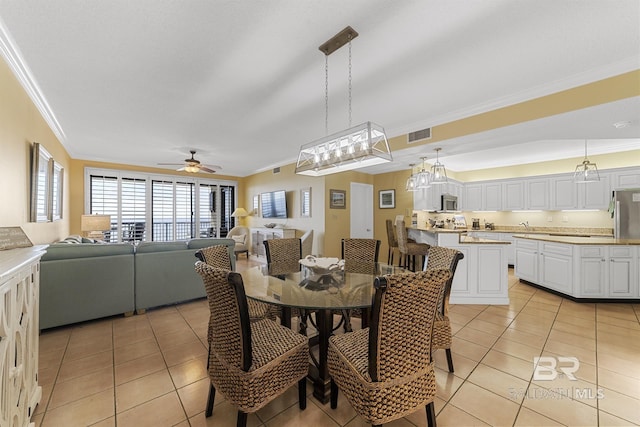 dining area featuring ceiling fan, visible vents, crown molding, and light tile patterned floors