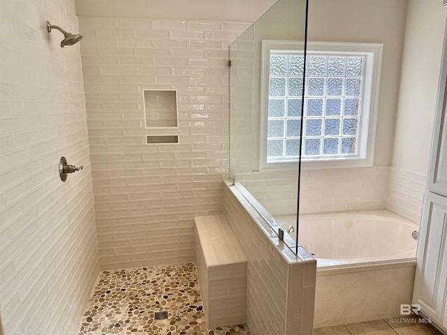 full bath featuring a garden tub, tiled shower, and tile patterned floors