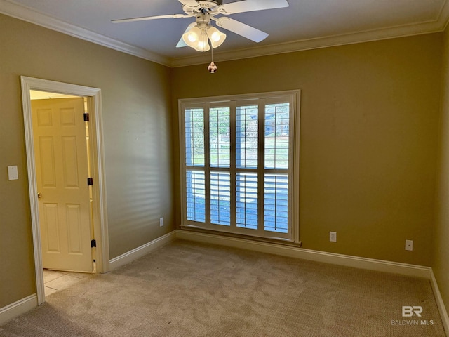 empty room with light carpet, ceiling fan, baseboards, and crown molding