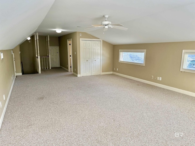 additional living space with carpet floors, baseboards, vaulted ceiling, and a ceiling fan